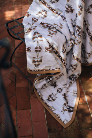 Blanket on the outdoor chair hanging messily with sun hitting the terracotta tiles