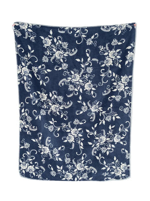 A navy blue blanket or throw with an all-over white floral and vine pattern, shown hanging flat against a plain white background.